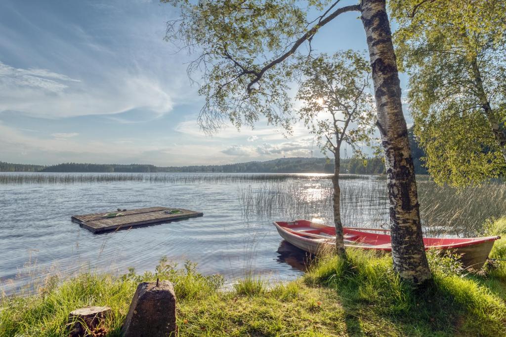 a couple of boats on a lake with a dock at Lake cottage near Isaberg in Åsenhöga