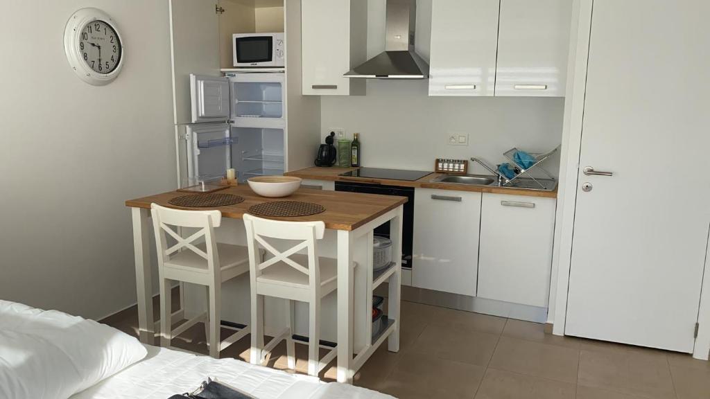 - une petite cuisine avec une table et deux tabourets dans l'établissement Terrasses de Malmedy Studio 331-BOLY, à Malmedy