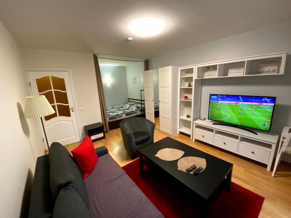 a living room with a couch and a flat screen tv at Vilnius central studio apartment in Vilnius