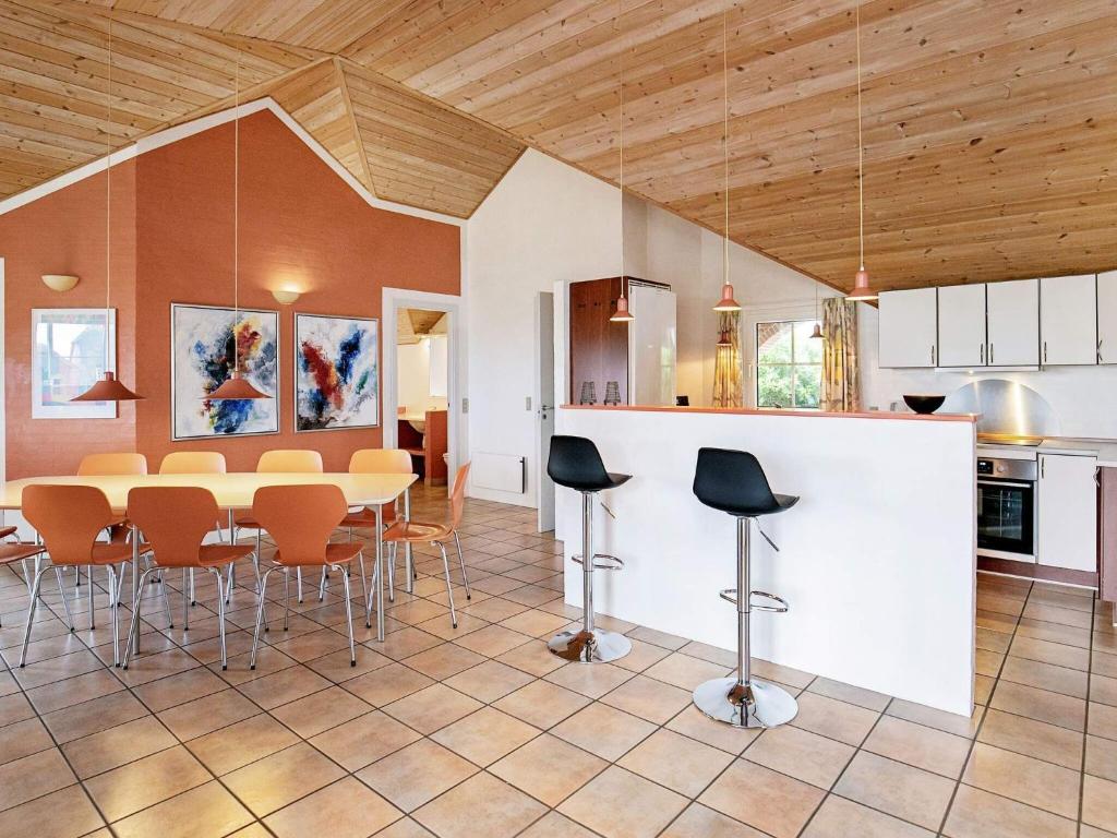 eine Küche und ein Esszimmer mit einem Tisch und Stühlen in der Unterkunft 10 person holiday home in Bl vand in Blåvand