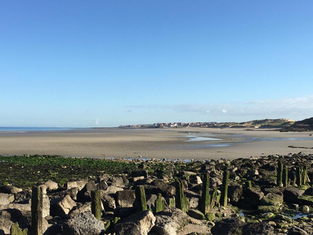- une vue sur une plage de rochers et l'océan dans l'établissement L Horizon vue mer, à Wimereux