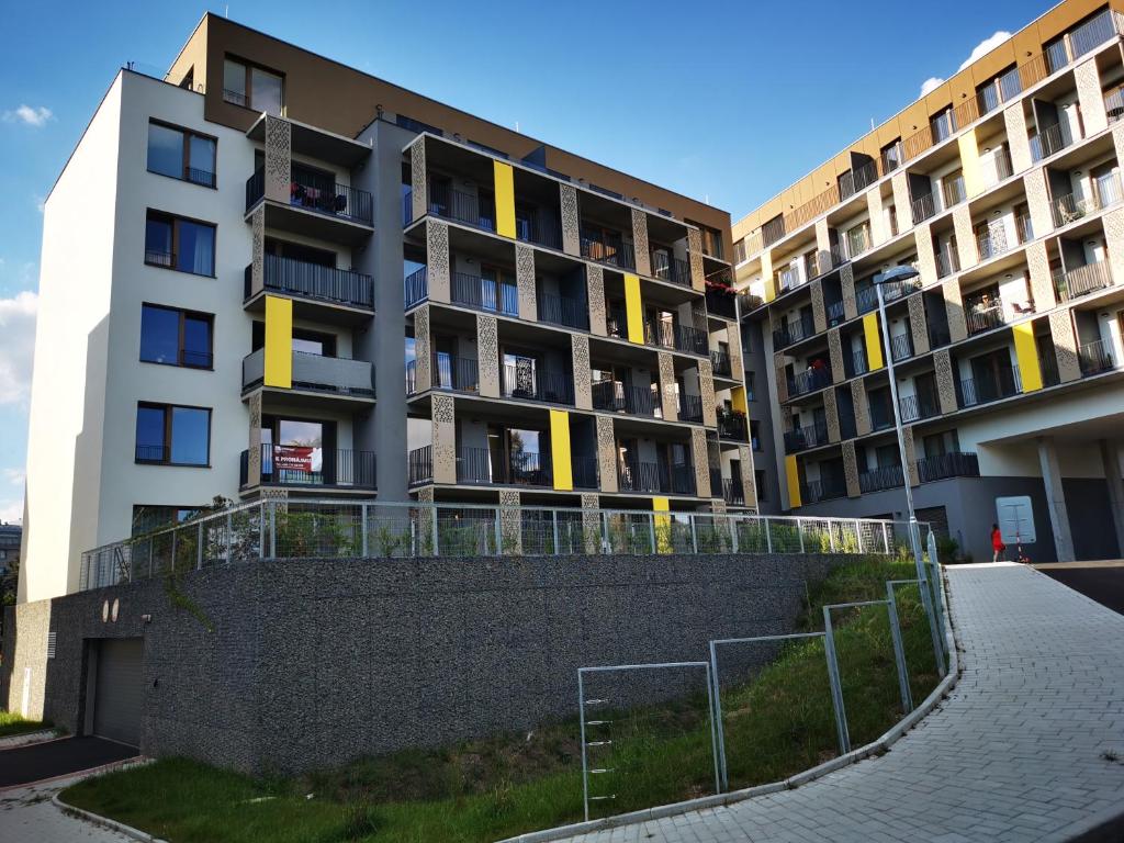 an apartment building with a fence in front of it at Apartmán Mlýnská Strouha in Pilsen