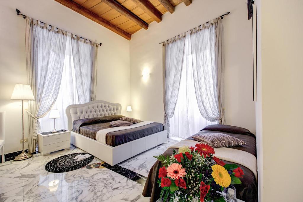 a bedroom with two beds and flowers on the floor at MyTimeRome in Rome