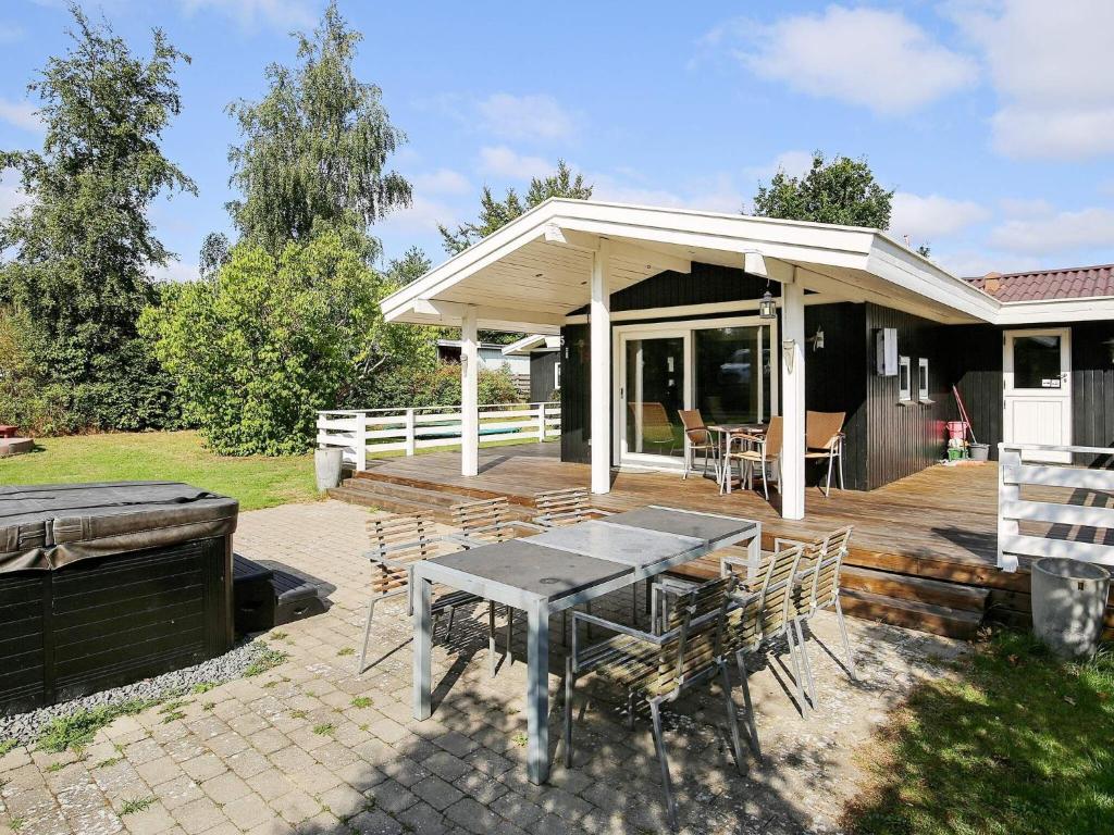 une terrasse avec une table et des chaises devant une maison dans l'établissement 6 person holiday home in J gerspris, à Hornsved