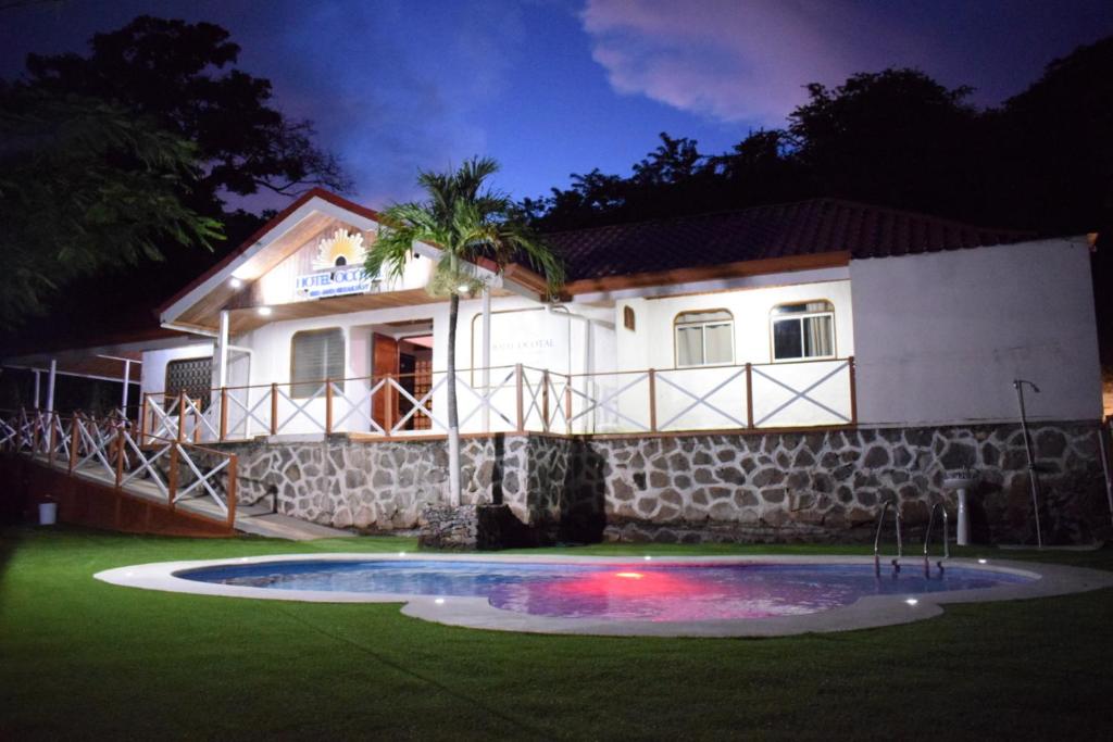 une maison avec une piscine dans la cour la nuit dans l'établissement Hotel Ocotal Bed & Breakfast, à Ocotal