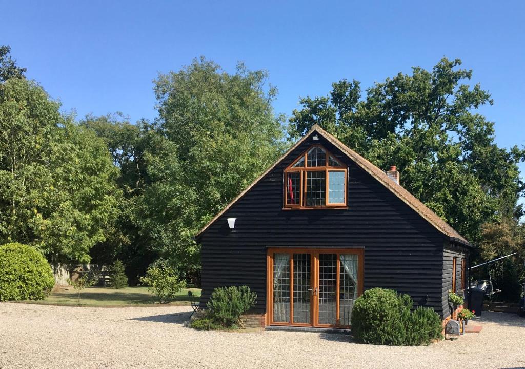 a black house with a gambrel roof at The little house in West Hanningfield