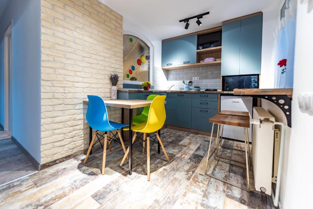 a kitchen with blue cabinets and yellow chairs at Central Garden Apartments in Sibiu