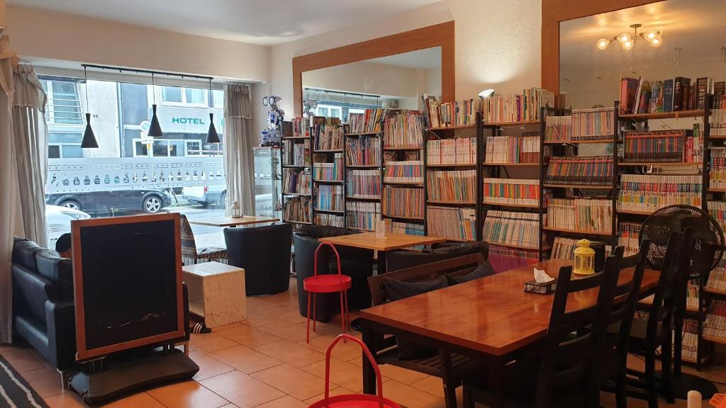 una biblioteca con muchos libros en estanterías en Hotel Ko en Düsseldorf