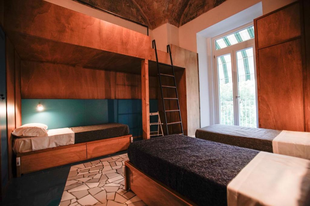 1 dormitorio con 2 literas y ventana en NAP Hostel Spaccanapoli, en Nápoles