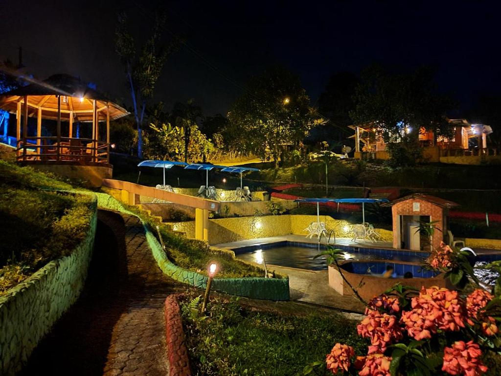 a night view of a swimming pool at a resort at Hostería Kasadasa in Santo Domingo de los Colorados