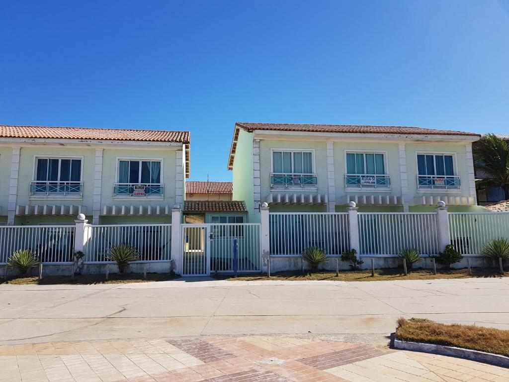 una cerca blanca frente a una casa en Cabo frio Beira mar Praia do Peró, en Cabo Frío