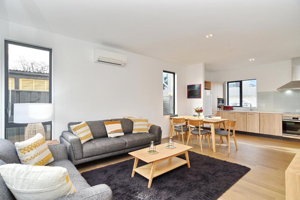 a living room with a couch and a table at Salisbury Style - Brand new city apartment - Christchurch Holiday Homes in Christchurch