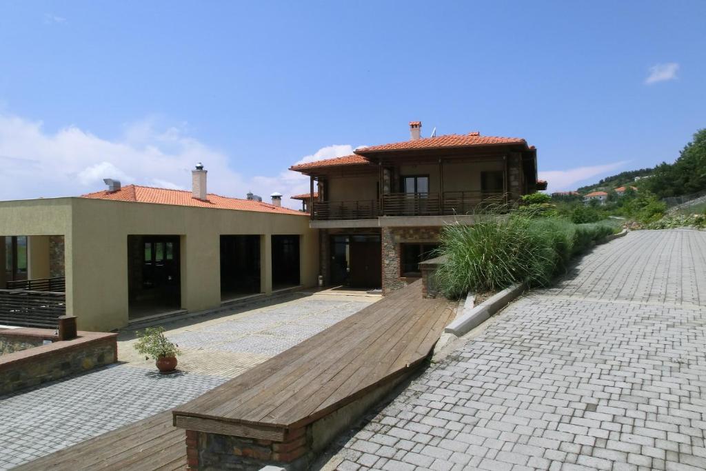 uma casa com um deque de madeira em frente em Iberis Hotel em Siátista