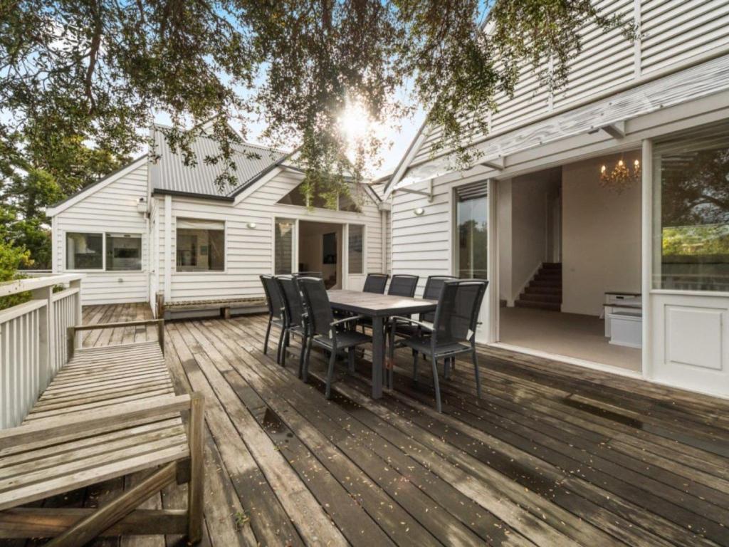 een houten terras met een tafel en stoelen op een huis bij Blairgowrie Hamptons Style in Blairgowrie