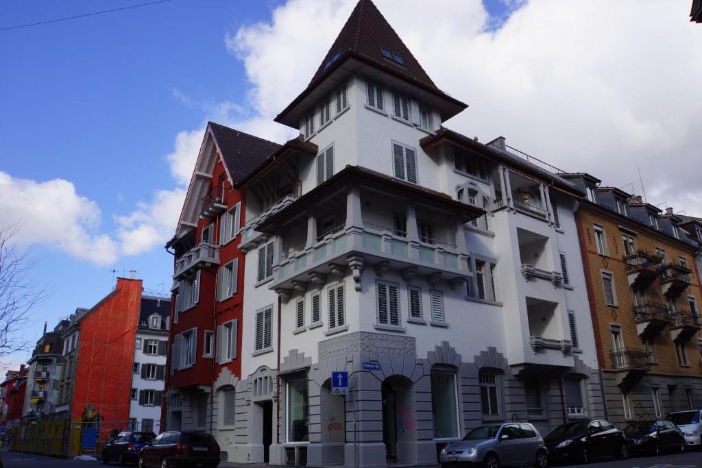 a white building with a turret on a street at Luxury Apartments by Livingdowntown in Zurich