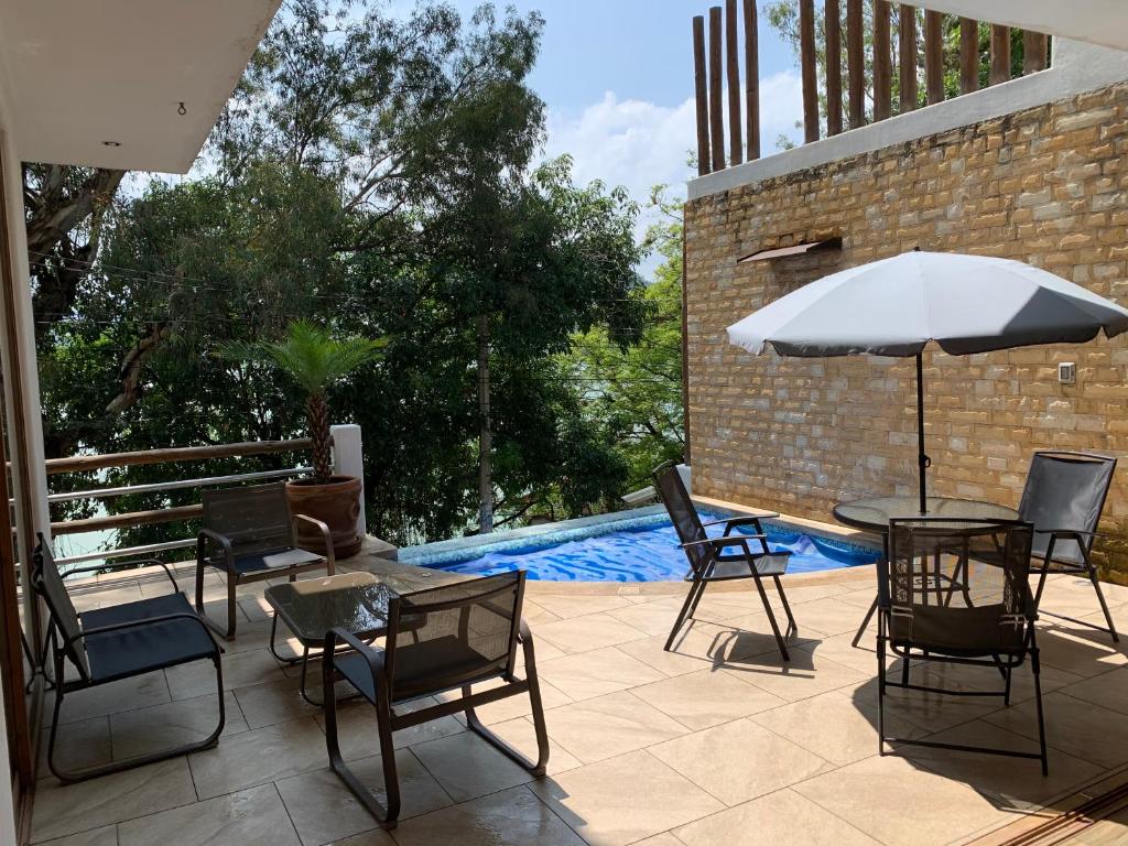 patio con tavolo, sedie e ombrellone di Casa Belmez a Valle de Bravo