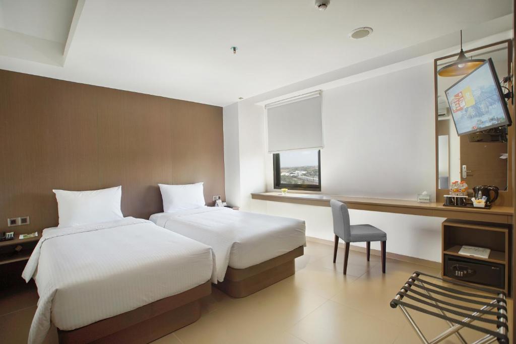 Postel nebo postele na pokoji v ubytování Malioboro Prime Hotel