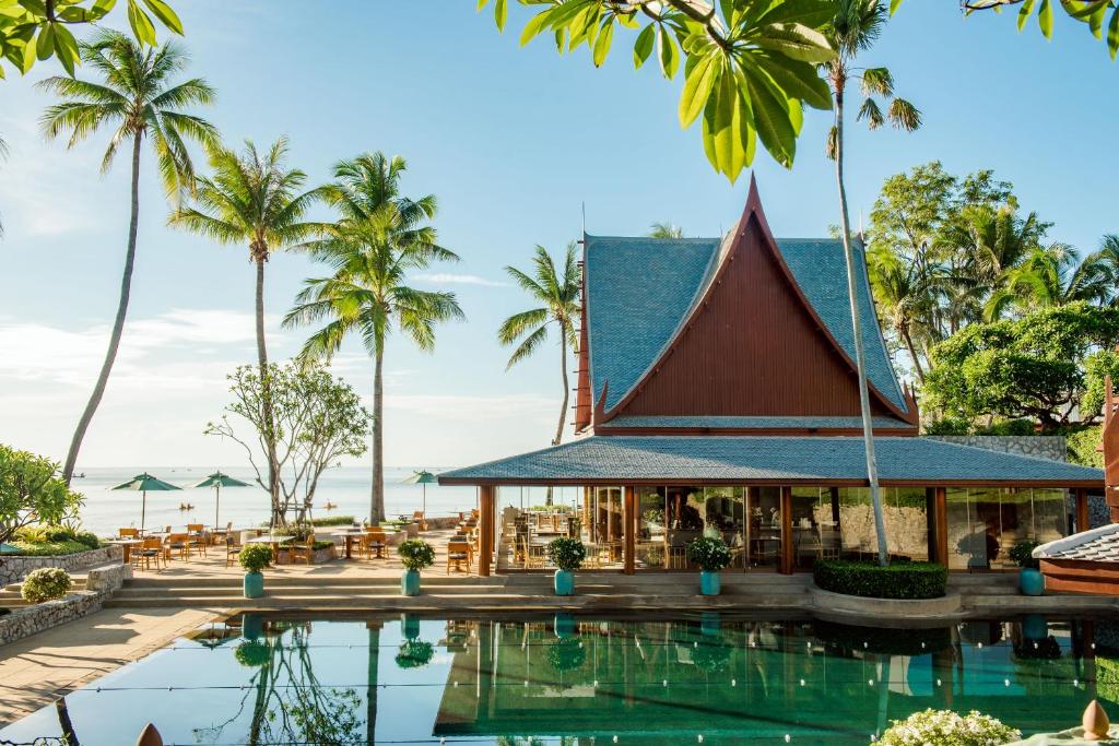 ośrodek z basenem i palmami w obiekcie Chiva-Som International Health Resorts w mieście Hua Hin