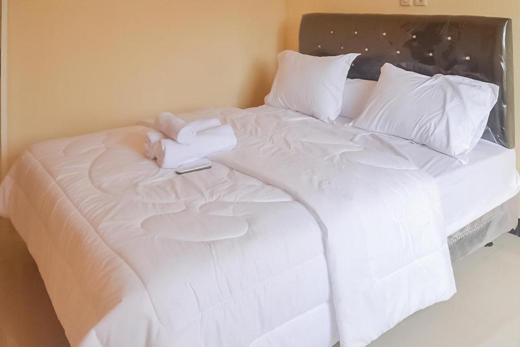 a white bed with a white sheets and pillows at Artayya Puri Homestay near Terminal Purabaya Madiun Mitra RedDoorz in Madiun