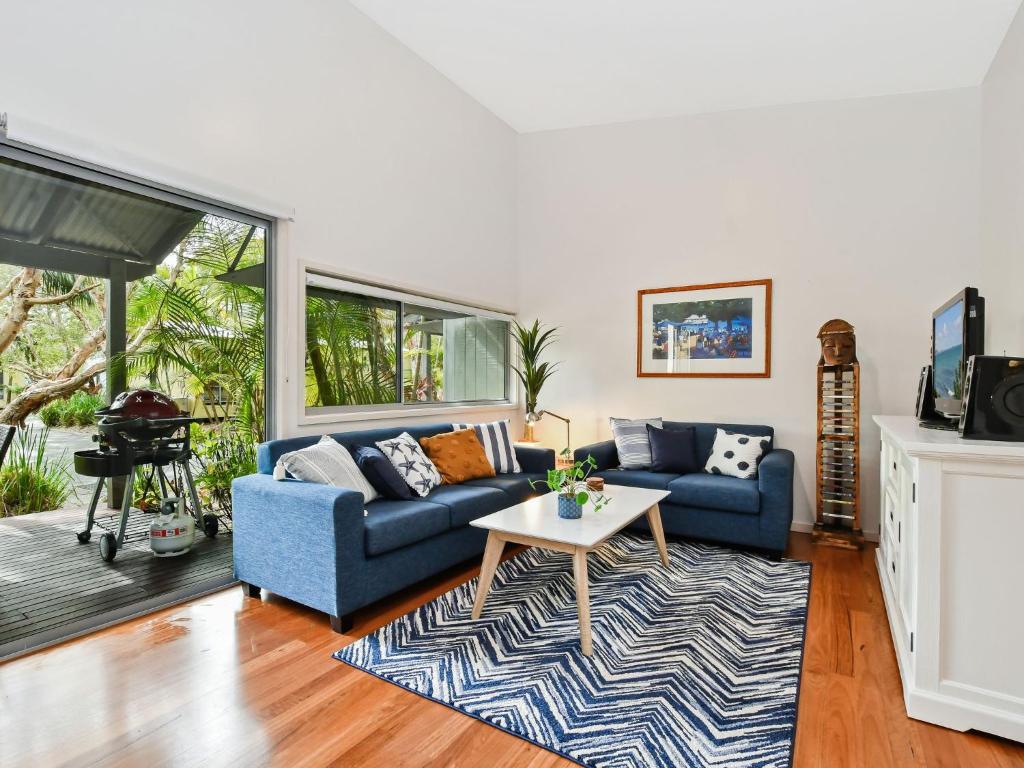 Mobys Resort 08 في Boomerang Beach: غرفة معيشة مع أريكة زرقاء وطاولة