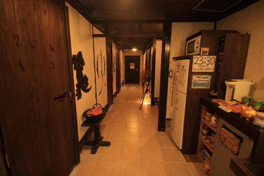 un pasillo de una cocina con una persona caminando por el pasillo en Taketomijima Guesthouse and je Taime, en Taketomi