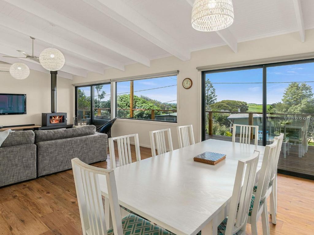 a dining room and living room with a table and chairs at Waikiki Views in Smiths Beach