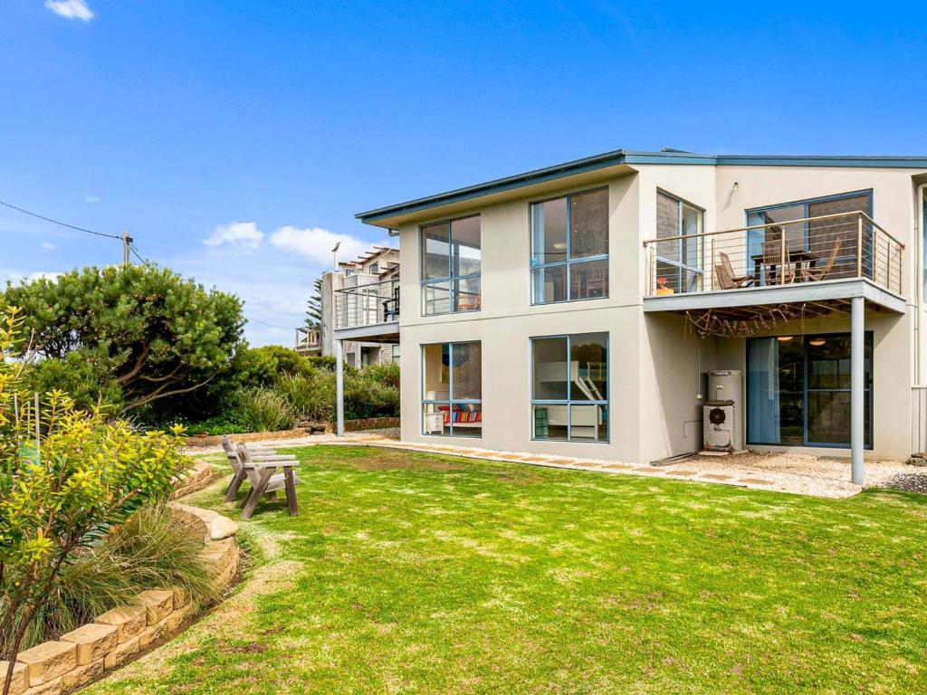 a large white house with a grass yard at Adnajur in Surf Beach