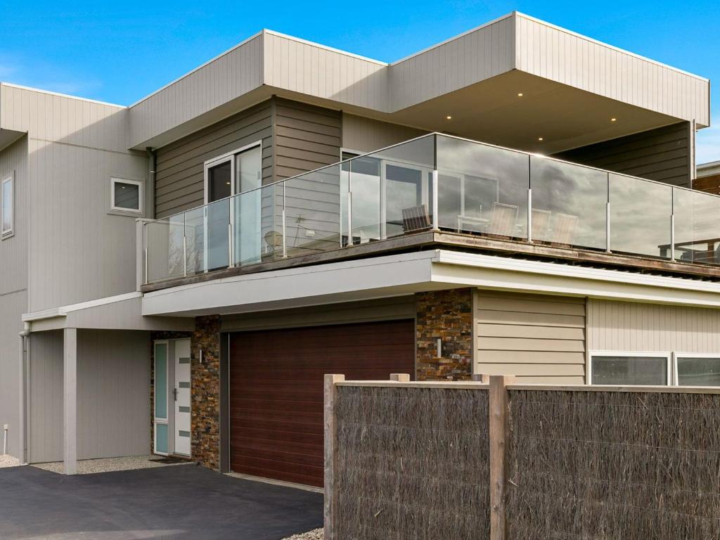 a large house with a balcony on top of it at Swan Bay Views in Surf Beach