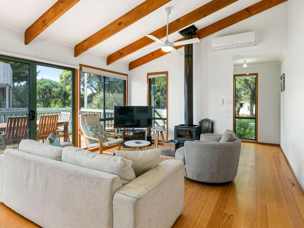 Sala de estar con 2 sofás y TV en Surf Rest'n Bay, en Cape Woolamai