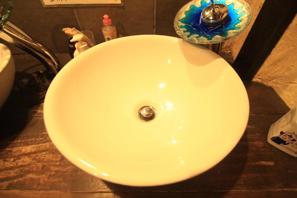 a white sink in a bathroom with aaucet at Taketomijima Guesthouse and je Taime in Taketomi