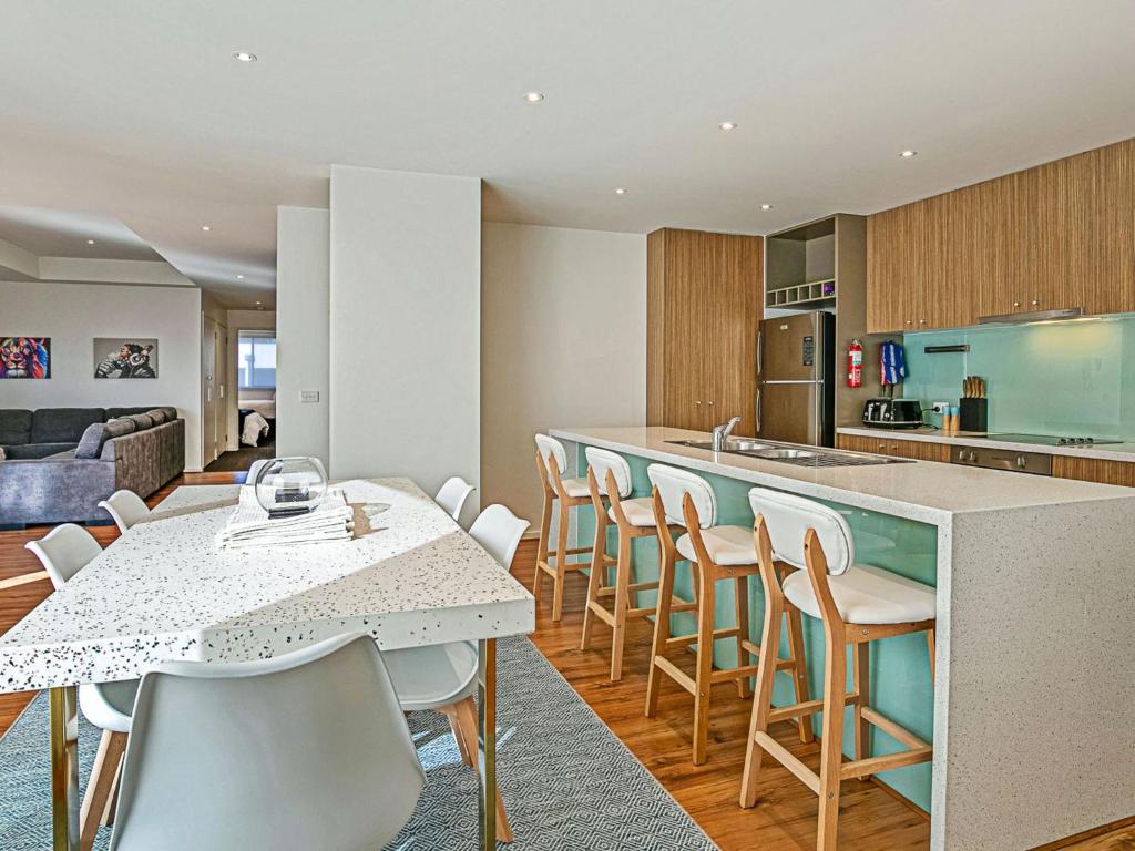 cocina y sala de estar con mesa y sillas en Saltwater Haven, en Cowes