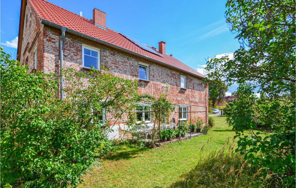 a brick house with a red roof and a yard at 5 Bedroom Amazing Apartment In Uckerland in Uckerland