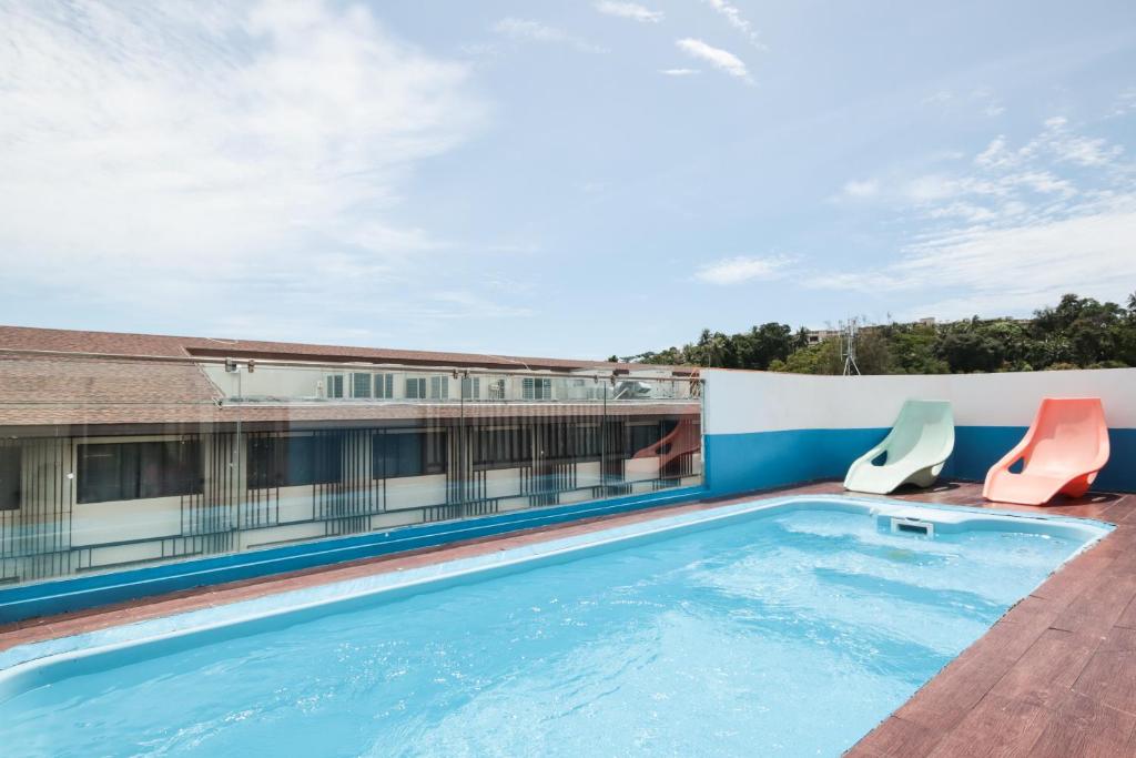 a swimming pool on the roof of a hotel at OYO 1074 Fin Hostel in Kata Beach