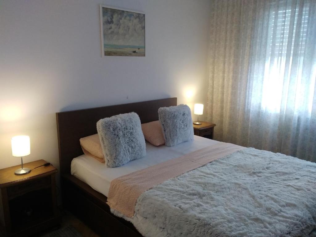 - une chambre avec un lit avec deux oreillers et deux lampes dans l'établissement Ultracentral Apartments, à Bucarest