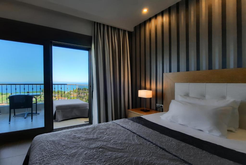 a bedroom with a large bed and a balcony at Panorama Dream Studios B in Vourvourou