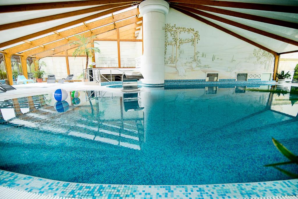 a large swimming pool in a house with a large at Pałac Piorunów & Spa in Kwiatkowice