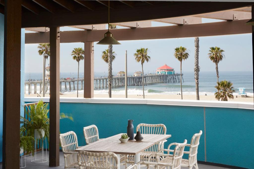 einen Tisch und Stühle mit Blick auf den Strand in der Unterkunft Kimpton Shorebreak Huntington Beach Resort, an IHG Hotel in Huntington Beach