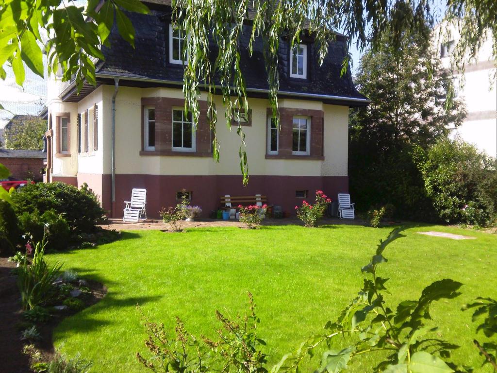 una casa con un césped verde delante de ella en Villa Mondial en Wadern