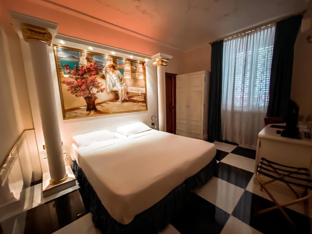 a bedroom with a large bed and a large window at Hotel Palladium Palace in Rome
