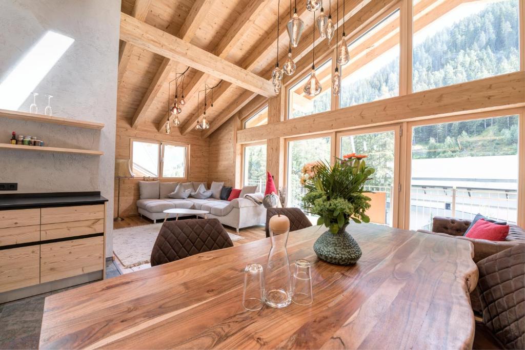 uma cozinha e sala de jantar com uma mesa de madeira e cadeiras em Quality Hosts Arlberg - ALPtyrol Appartements em Sankt Anton am Arlberg