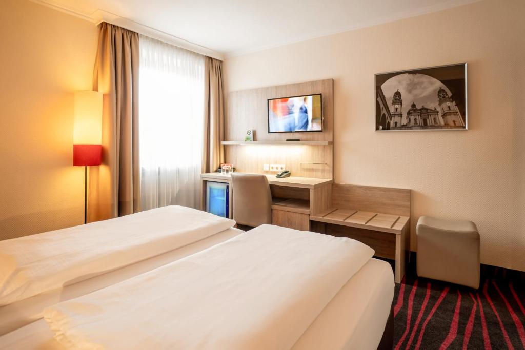 a hotel room with two beds and a television at Europäischer Hof in Munich