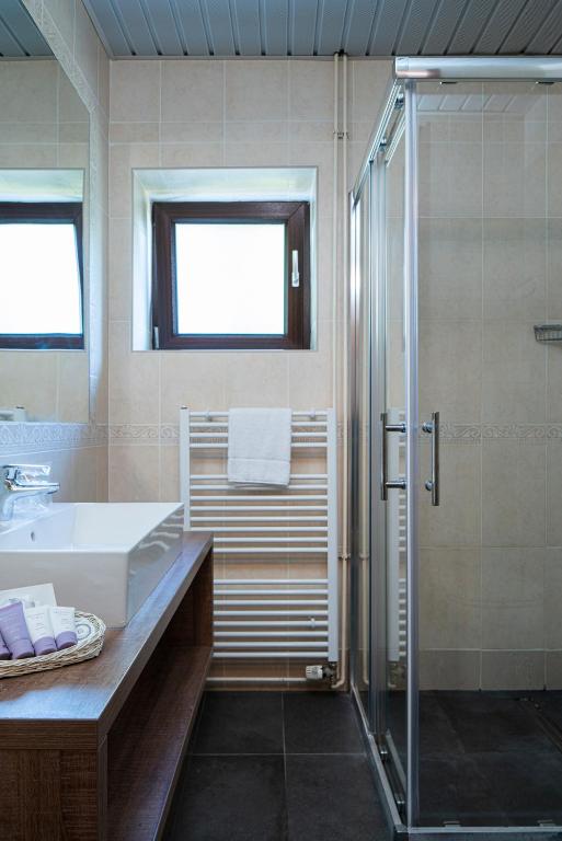 a bathroom with a shower and a sink and a tub at Hotel Flores in Poreč