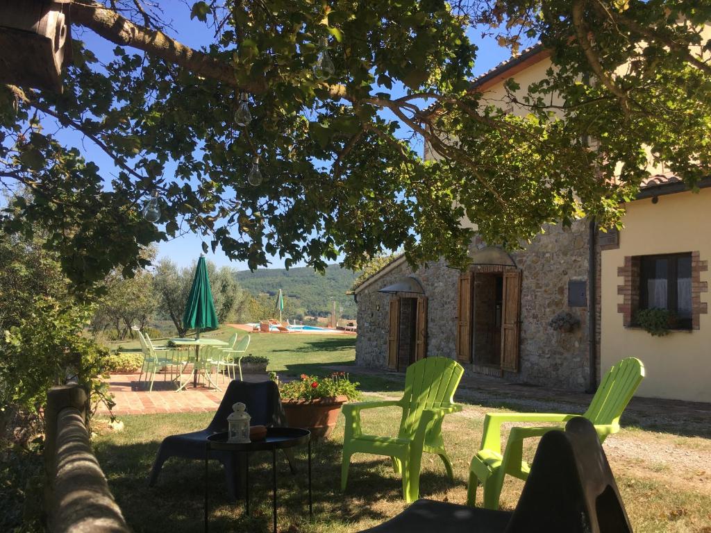 a yard with chairs and a table and a building at Villa San Regolino whit private pool in Radicondoli