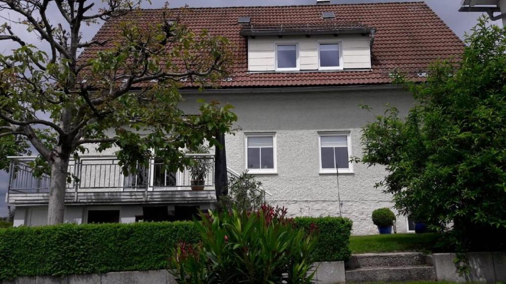 ein weißes Haus mit Balkon darüber in der Unterkunft Ferienwohnungen Sachsenblick in Grafenau