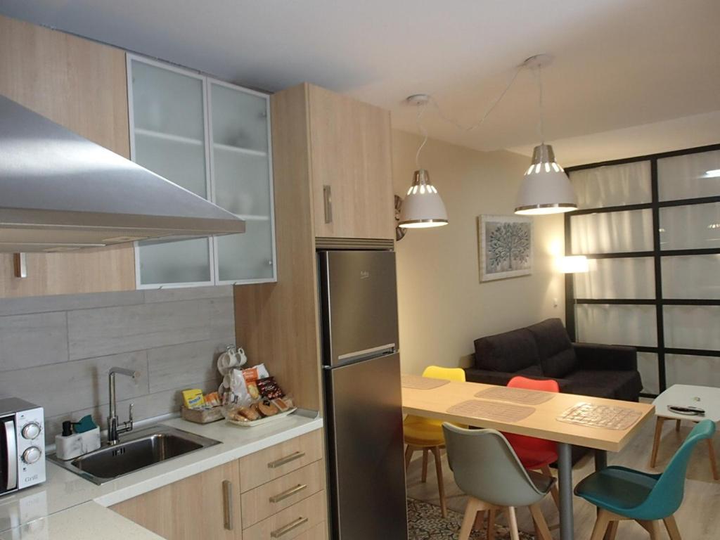 uma cozinha com uma mesa e uma cozinha com um sofá em Apartamento El Aljibe de la Luz em Toledo