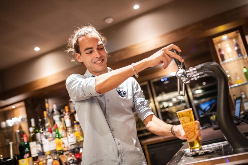 a bartender making a drink at a bar at Le Taos in Tignes