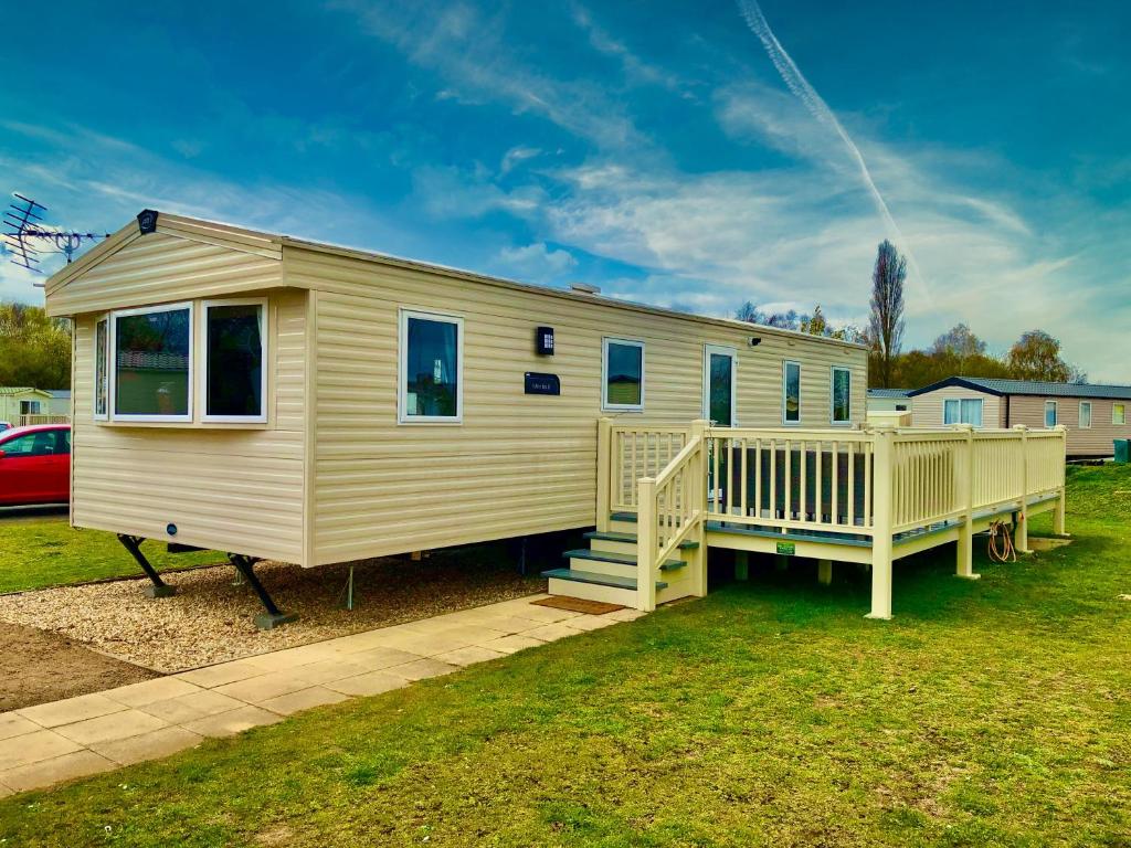 a mobile home with a porch and a deck at Celebration Tattershall with Private Hot Tub in Tattershall