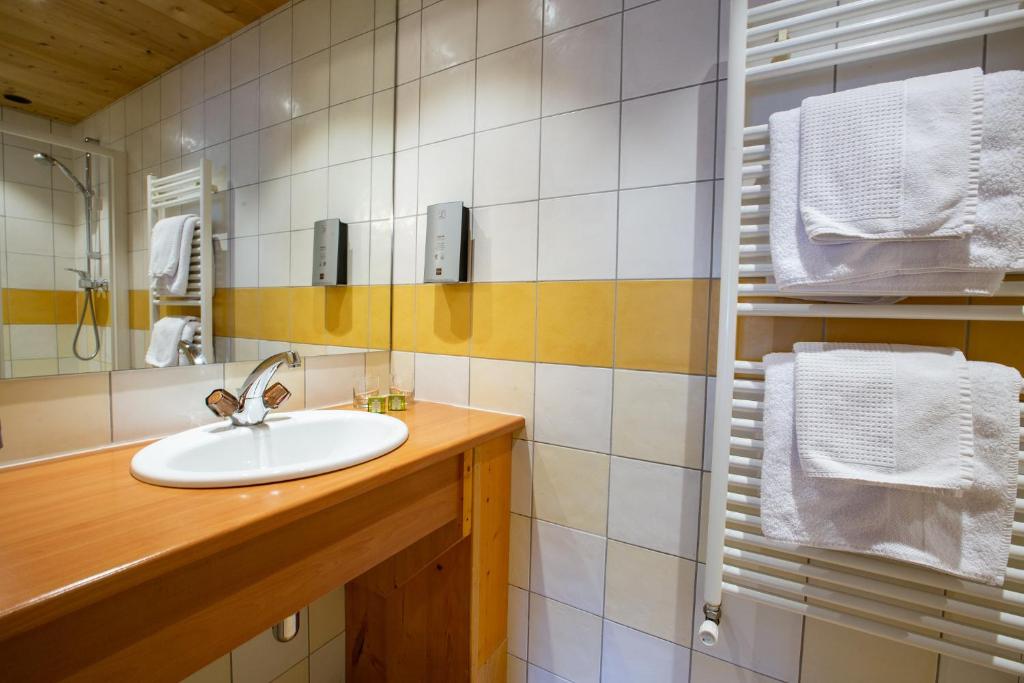 a bathroom with a sink and a mirror at Hotel Les Bruyères in Morzine