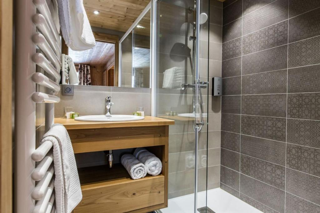 a bathroom with a sink and a shower at Hotel Les Bruyères in Morzine