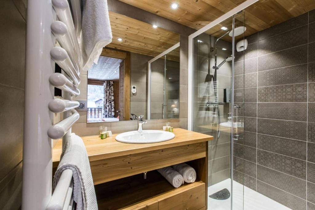 a bathroom with a sink and a shower at Hotel Les Bruyères in Morzine
